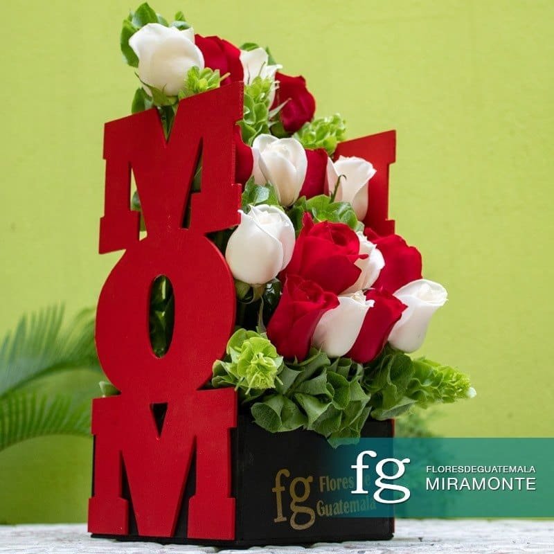 Red and white roses arranged around decorative red letters spelling MOM.
